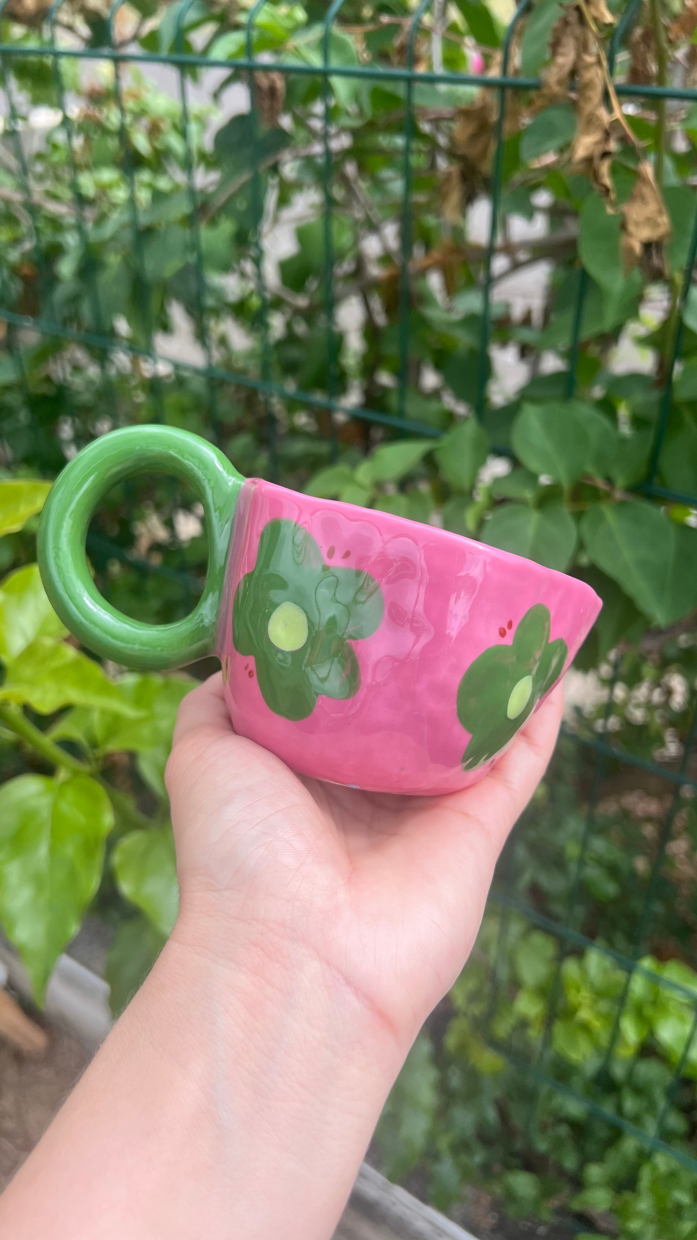 Taza rosa con handle verde y flor verde
