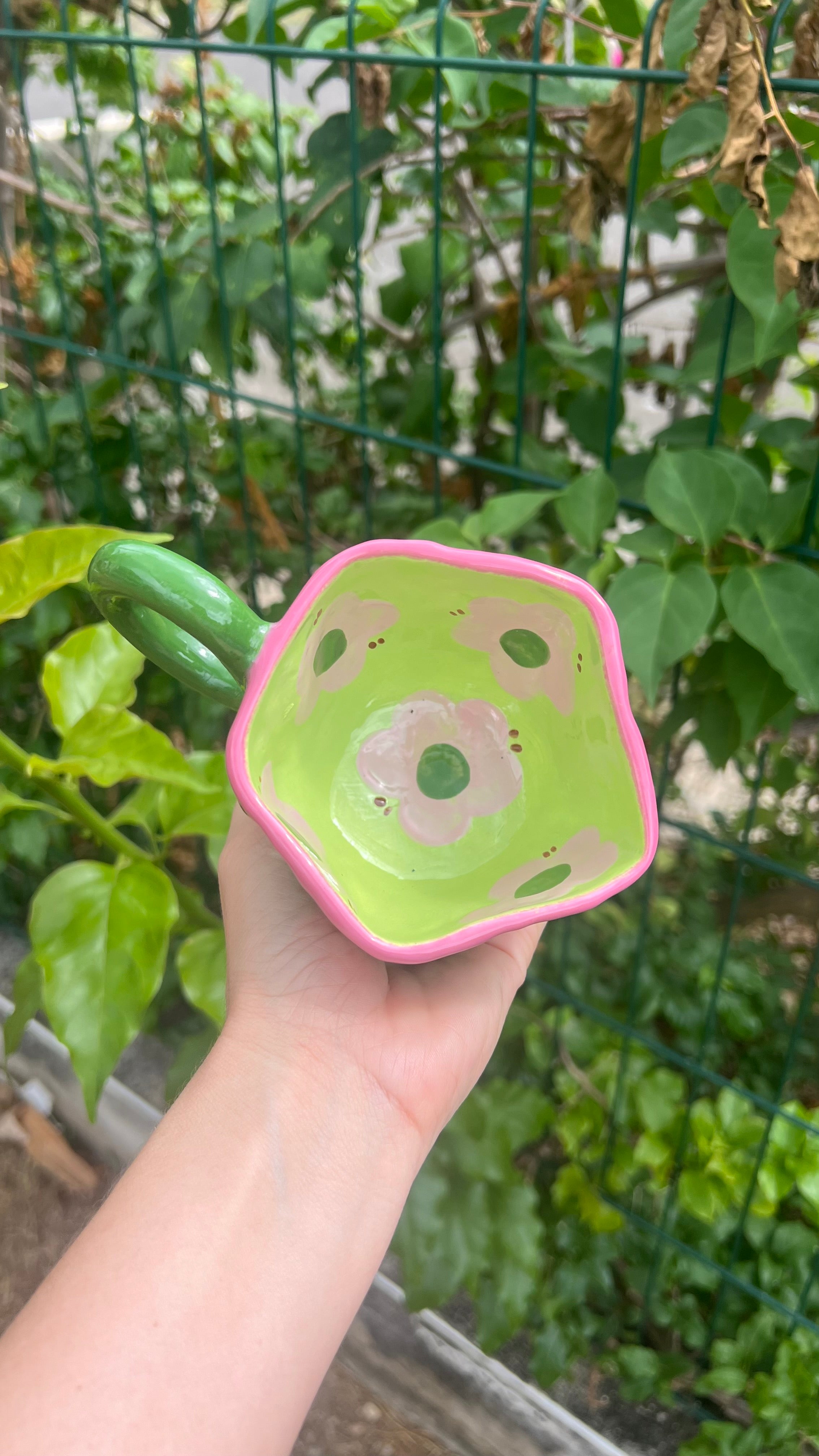 Taza rosa con handle verde y flor verde
